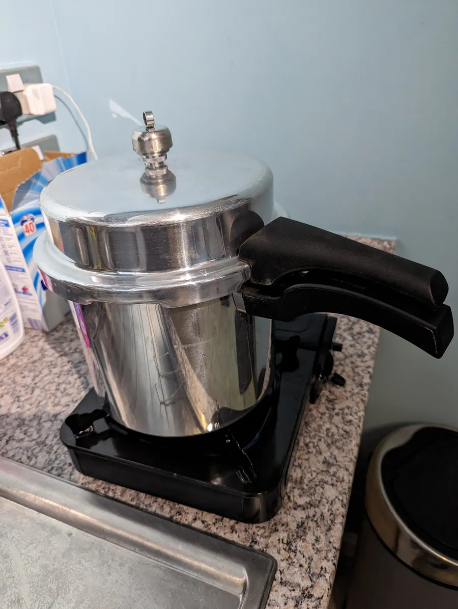 A pressure cooker on a gas hob being used to sterilise vials